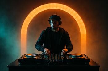 DJ na pódiu pod oblúkom svetiel